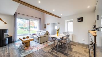 Una sala moderna con sofá, mesa de centro y comedor.