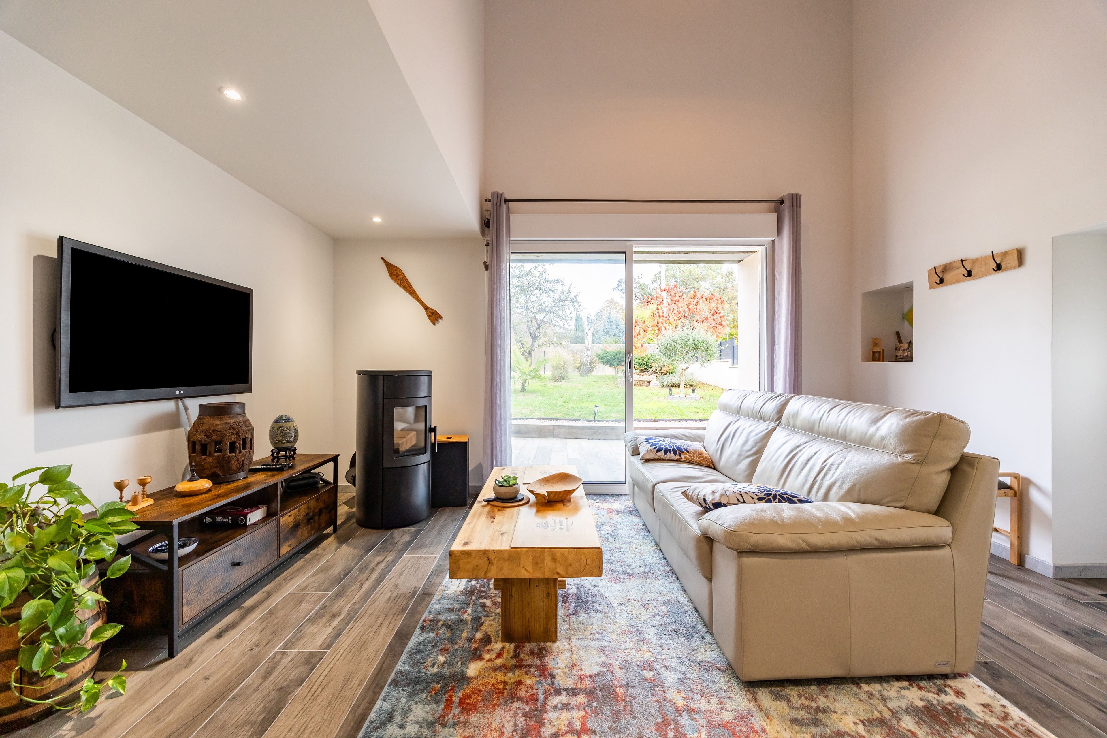 Una sala de estar moderna con un televisor de pantalla plana, un sofá, una mesa de centro y una chimenea.