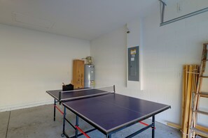 A ping pong table in a room with white brick walls, a water heater, and a ladder. - 12 Mi to Disney! Family Home ChampionsGate Golf (Davenport)