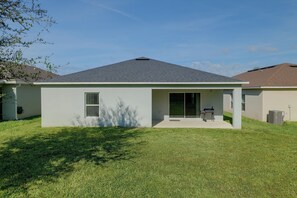 A single-story house with a flat roof, a covered patio, and a lawn. - 12 Mi to Disney! Family Home ChampionsGate Golf (Davenport)