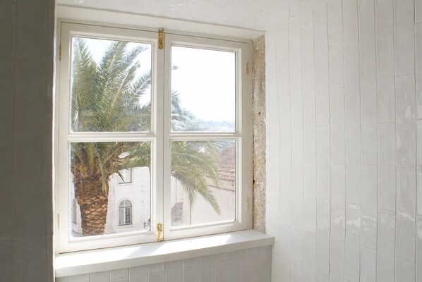 Ein Fenster mit Blick auf Palmen und ein Gebäude.