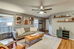 A living room with a sofa, coffee table, and a ceiling fan. - Easy Airport Access! Austin Home w/ Patio (Austin)