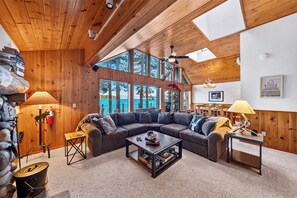 A cozy living room with a sectional sofa, a coffee table, and a fireplace. - Lakefront Retreat • Boat Dock + Hot Tub | Near Beach | Meeks Bay Chalet (Tahoma)