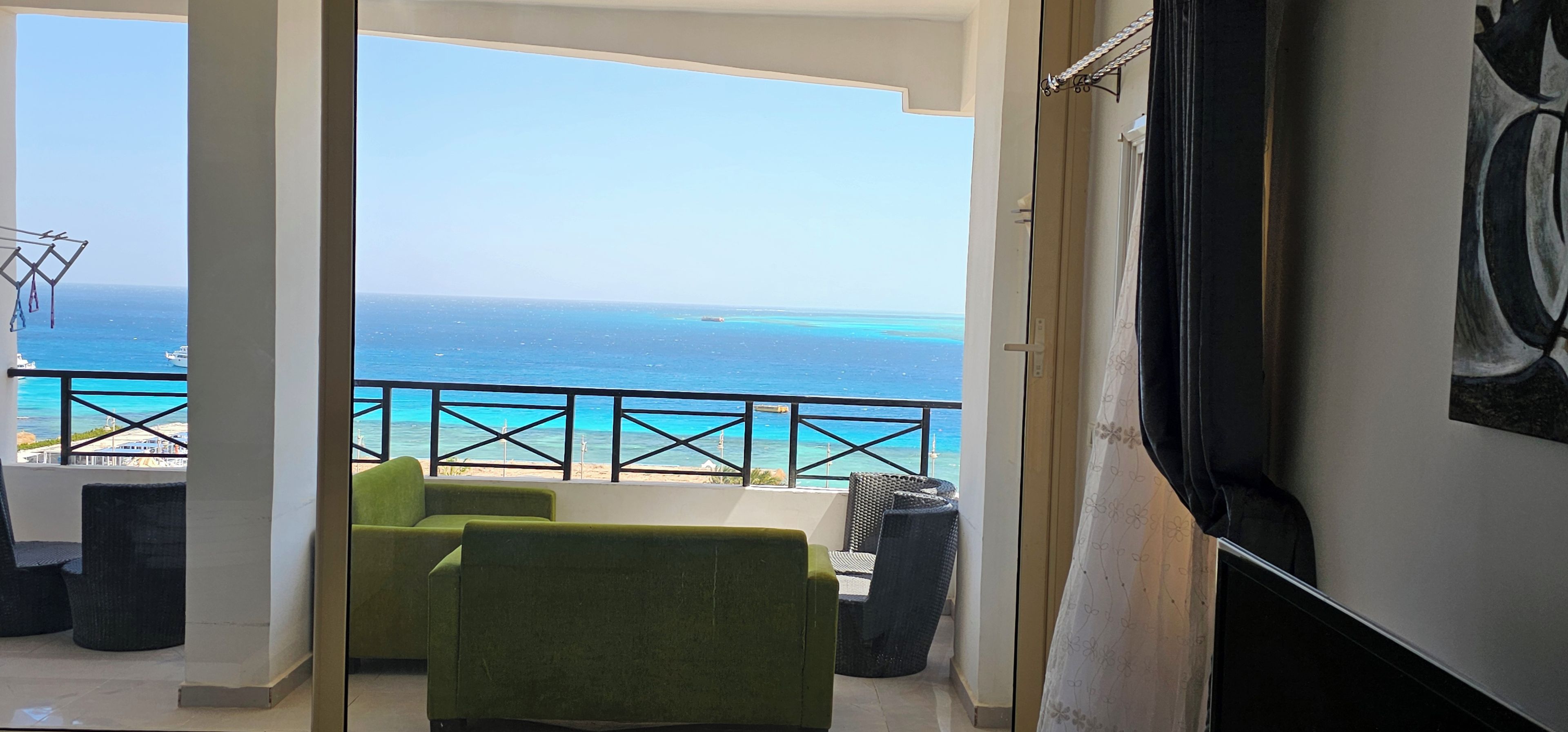Een balkon met uitzicht op de oceaan en een stoel.