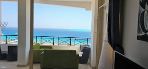 Een balkon met uitzicht op de oceaan en een stoel.