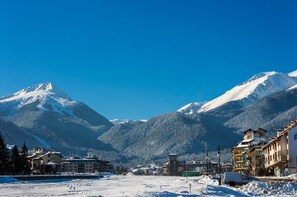 Eine verschneite Bergstadt mit Häusern und blauem Himmel.