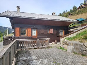 A wooden cabin with a metal roof, a wooden fence, and a stone wall. - Chalet Pelou - 7 peoples - Morzine (Morzine)