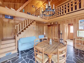 A wooden interior with a staircase, a dining table with chairs, a sofa, and a chandelier. - Chalet Pelou - 7 peoples - Morzine (Morzine)