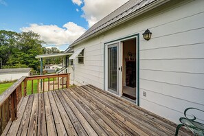 A wooden deck with a glass door leading to a room with a brick fireplace. - 1 Mi to Downtown! Cute Cambridge Getaway (Cambridge)