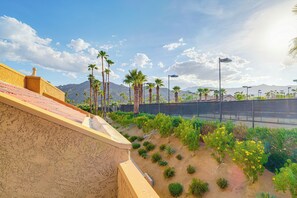 A landscaped area with palm trees, a fence, and a mountain in the background. - Sip, Soak & Stargaze: Palm Desert Retreat! (Palm Desert)