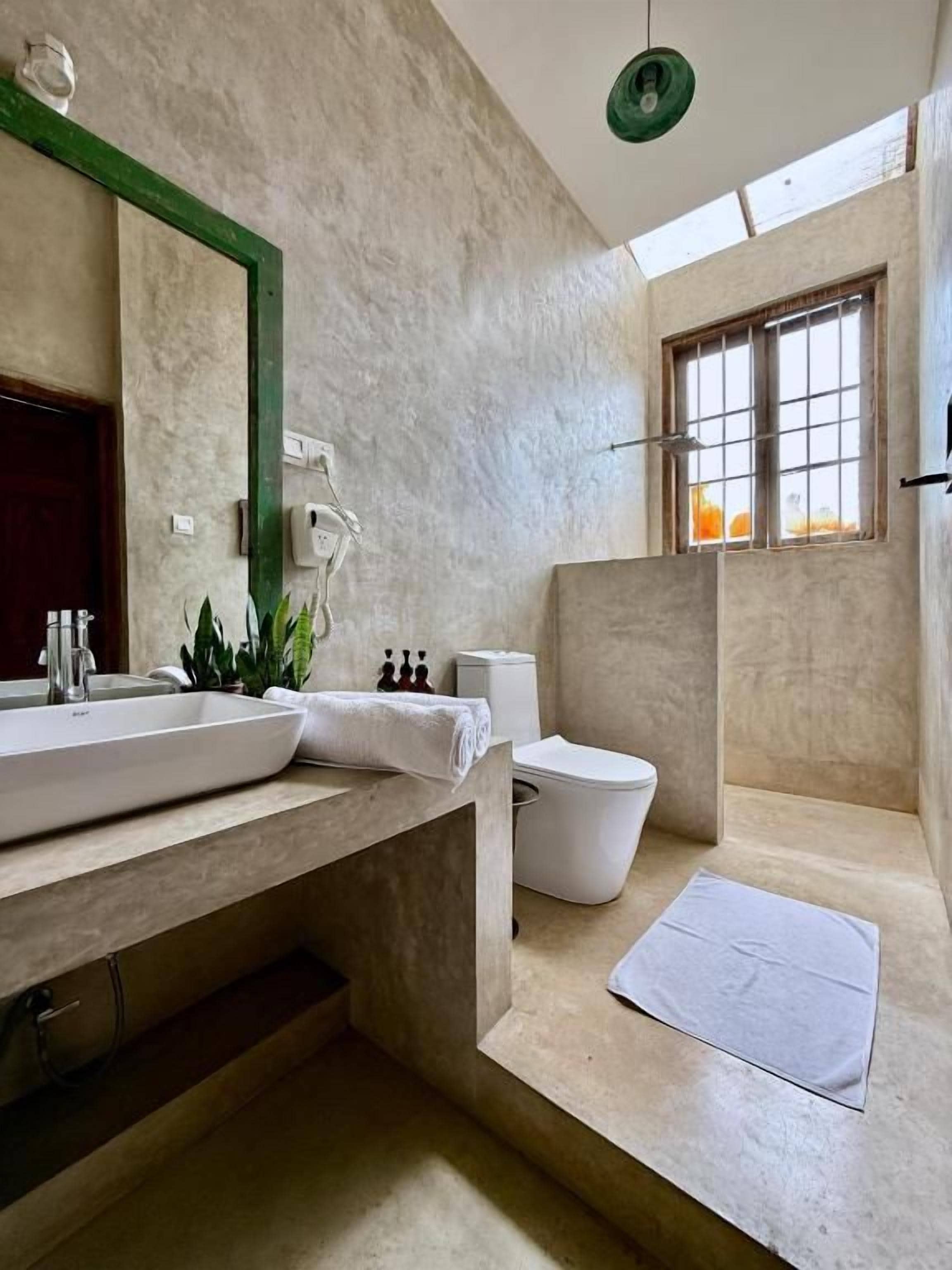 Un baño con un lavamanos grande, un inodoro y una bañera.