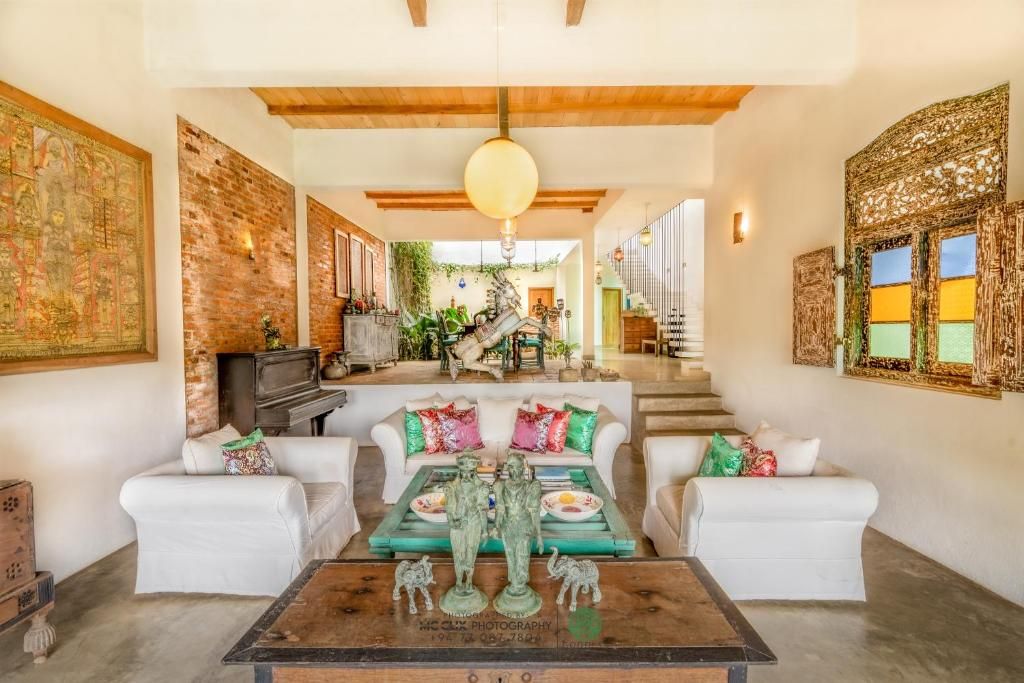 A spacious living area with a high ceiling, a staircase leading to an upper level, and a fireplace.