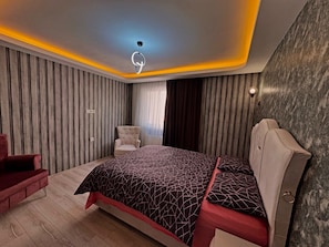 Un dormitorio moderno con cama, una silla y cabecera.
