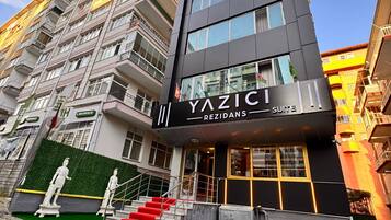 Un edificio moderno con un letrero que dice 'YAZICI REZIDANS SUITE'.