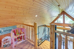 Ein Holzinnenraum mit hohen Decken, einer Treppe und einem großen Fenster mit Blick auf eine natürliche Landschaft.