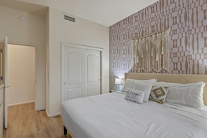 Ein Schlafzimmer mit einem Bett, einer Tür und einer Wand mit Muster.