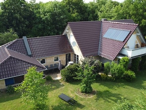 A residential property with a sloped roof, a garden area, and a solar panel installation. - Holiday Home Kissner (Ilsenburg)