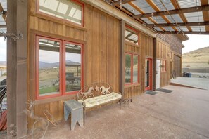 Ein Holzhaus mit großen Fenstern und einer überdachten Terrasse.