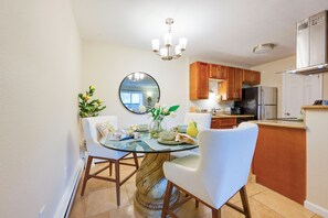 A dining area with a round table, chairs, and a mirror on the wall. - Flatiron Views, Pool Access! Boulder Extended Stay (Boulder)