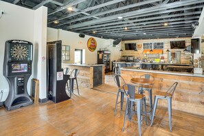 A bar area with a dartboard, a Red Bull Market sign, and a kitchen in the background. - Walk to Dining & Brewery! Cozy Kiel Apartment (Kiel)