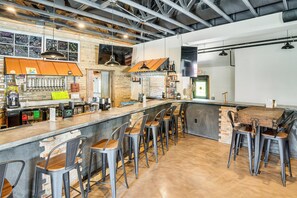 Eine Bar mit Sitzhocker, einer Theke und verschiedenen Flaschen und Gläsern.