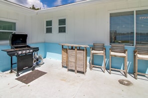 An outdoor patio with a grill, chairs, and a table. - Game Room & Hot Tub! Bayfront Family Gem (Fort Walton Beach)
