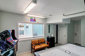 A room with a pool table, a neon sign, a bench, and a door. - Game Room & Hot Tub! Bayfront Family Gem (Fort Walton Beach)