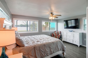 A bedroom with a bed, dresser, TV, and windows. - Game Room & Hot Tub! Bayfront Family Gem (Fort Walton Beach)