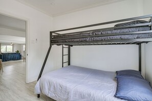 A bunk bed with a ladder, a blue pillow, and a white bedspread in a room with a wooden floor and white walls. - San Angelo Lake Escape: Dock & Fire Pit (San Angelo)