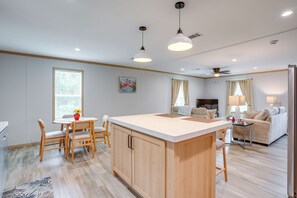 Een moderne keuken met houten kastjes, een centraal eiland en hanglampen.