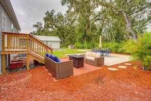 A backyard with a wooden deck, outdoor furniture, and a covered patio area. - Easy I-4 Access: Central Florida Home w/ Fire Pit (Plant City)