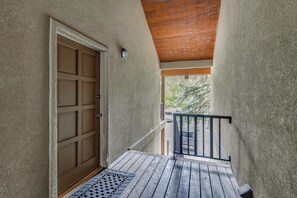 A covered outdoor area with a wooden door, a metal railing, and a view of the street. - Walk to Ski Slopes! Sun Valley Condo w/ Balcony (Ketchum)