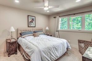 A bedroom with a bed, bedside lamps, a ceiling fan, a window with curtains, and a framed picture on the wall. - Walk to Ski Slopes! Sun Valley Condo w/ Balcony (Ketchum)