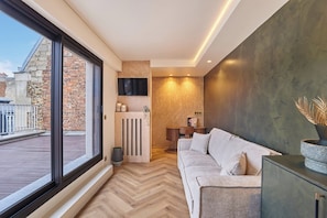 A modern living room with a large window, a sofa, a TV, and a fireplace. - New Studio Eiffel Tower-Trocader with terrace (Paris)