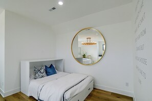A bedroom with a bed, a mirror, and a wall with motivational text. - Bright & Modern Studio, 15 Mi to Des Moines! (Waukee)