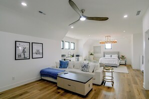 Un dormitorio moderno con cama, escritorio y ventilador de techo.