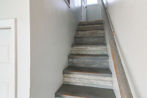 A narrow staircase with wooden steps and a white door at the top. - Water Views! Studio w/ Hot Tub & Boat Dock Access (Fort Walton Beach)