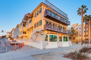 A multi-story building with balconies, a ground-level entrance, and a parking area. - Sun, Surf & Pier Views: Santa Monica Beach Condo! (Santa Monica)