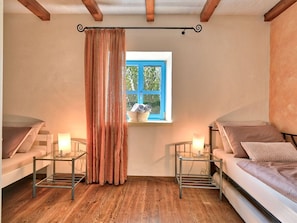 A room with two beds, a window with blue shutters, a curtain, and a table with a lamp. - Villa in Porec With Swimming Pool (Porec)