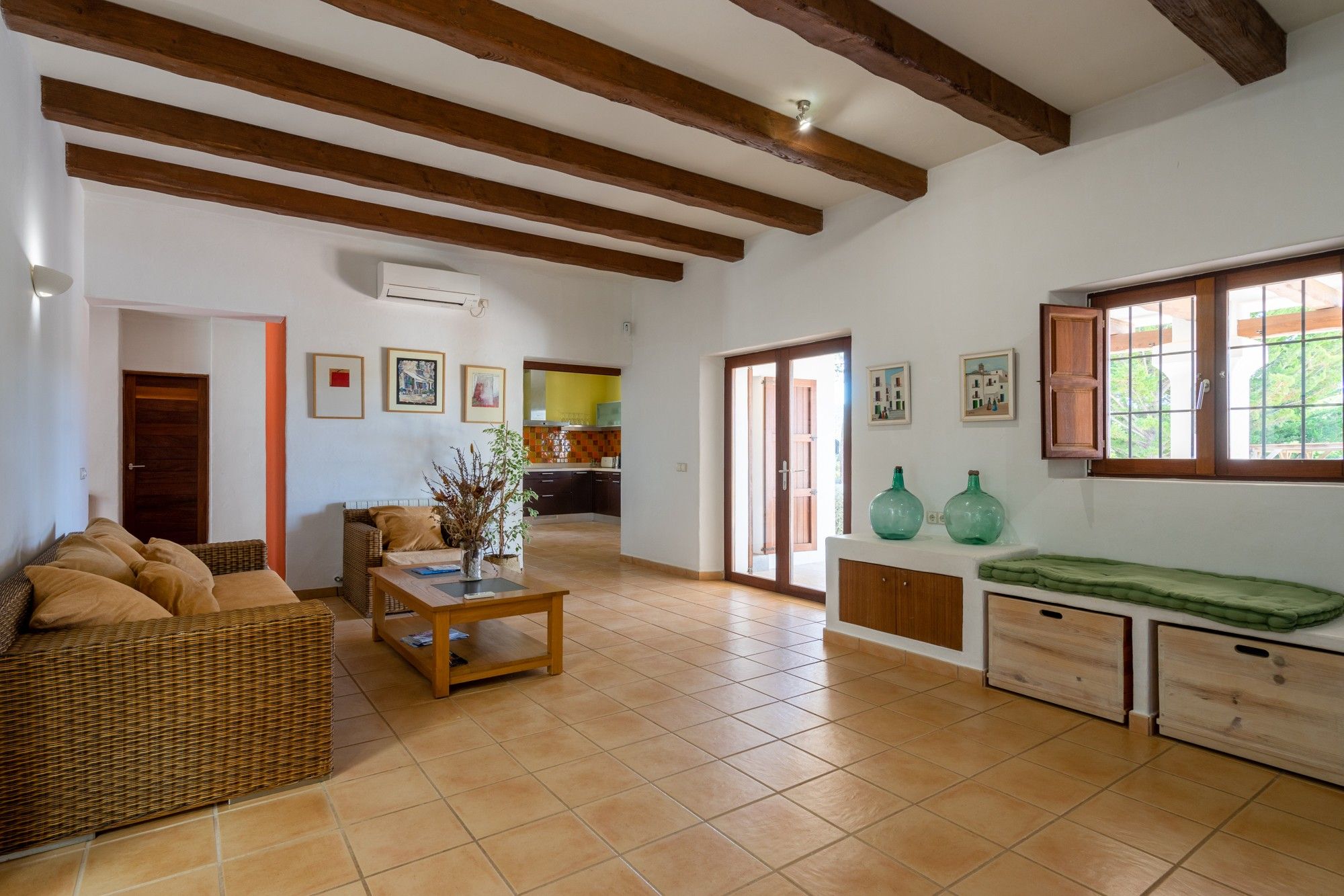 A spacious living area with a sofa, a coffee table, and a view into the kitchen.