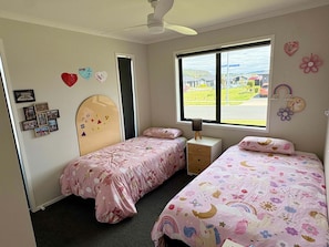 Un dormitorio con dos camas, una ventana con vistas y adornos en la pared.