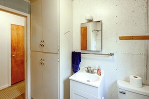 A bathroom with a white sink, a mirror, a towel rack, and a toilet.