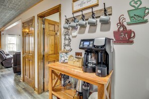 A coffee station with a coffee maker, cups, and a coffee grinder. - Ellijay Mtn Cabin w/ Hot Tub & Community Perks! (Ellijay)