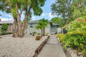 A residential property with a pathway leading to a house, surrounded by trees and a variety of plants. - Steps to Dtwn & Riverwalk! Retreat w/ Fenced Yard (Bradenton)