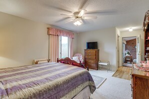A bedroom with a bed, dresser, vanity, and a television. - Private Yard & Patio! Hopewell Extended Stay (Hopewell)