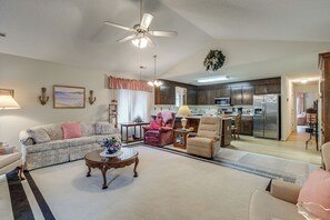 A spacious living room with a ceiling fan, a sofa, a coffee table, and a kitchen in the background. - Private Yard & Patio! Hopewell Extended Stay (Hopewell)