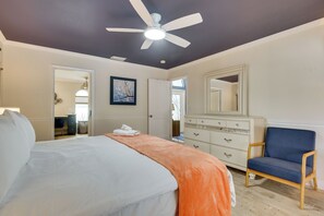 A bedroom with a bed, a dresser, a chair, and a ceiling fan. - Saltwater Pool & Firepits: Cape Coral Home (Cape Coral)