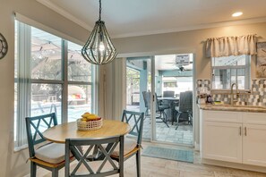 A kitchen with a dining area, large windows, and a view of the outside. - Saltwater Pool & Firepits: Cape Coral Home (Cape Coral)