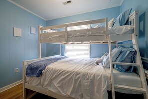 A bunk bed room with a window, white bedding, and blue pillows. - Salty Chateau Home w/ Ocean Views, Surf City (Surf City)
