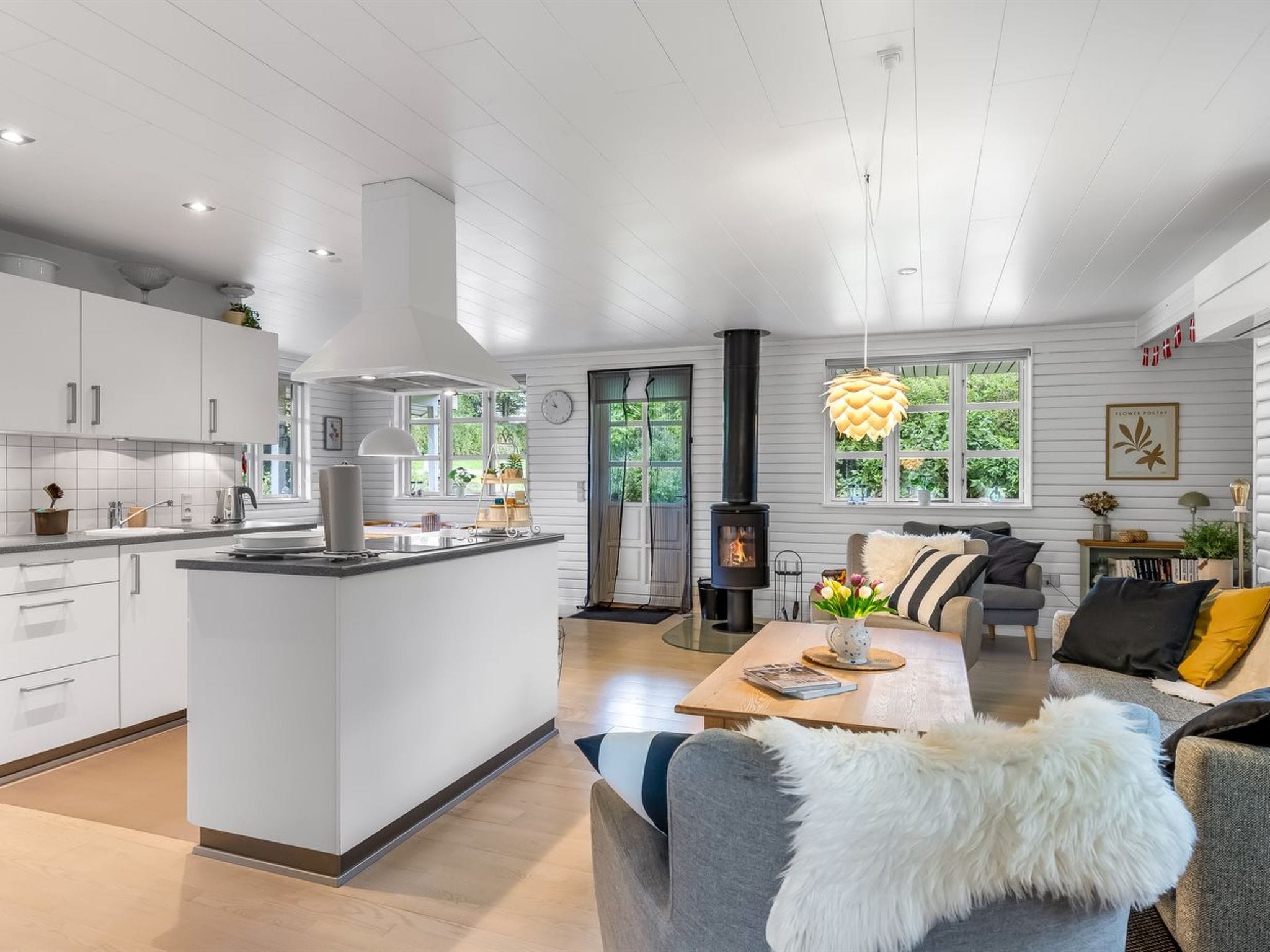 A modern kitchen with white cabinetry, a central island, and a built-in stove.